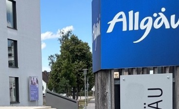 Das Landratsamt Ostalgäu und eine Plakatsäule mit dem Schriftzug "Allgäu" sind zu sehen.