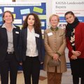 Vier Frauen stehen vor einer Pinnwand und einem Plakat der KAUSA-Landesstelle Bayern.