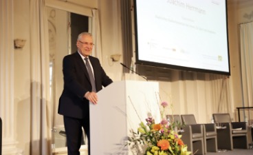 Innenminister Hermann steht auf dem Podium hinter einem Pult.