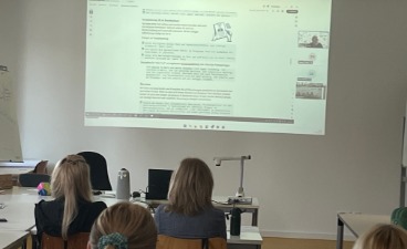 Online-Veranstaltung zu KI Auf dem Bild sind Hinterköpfe einzelner Teilnehmerinnen zu sehen, die auf eine Präsentation blicken.