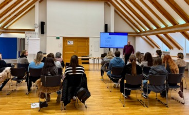 Workshop bei der VHS Landshut Mehrere Gäste sind von hinten zu sehen und schauen nach vorne zum Redner, der vor einer Präsentation steht.